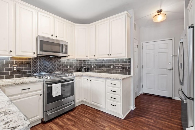 660 2nd St Unit 104, Minneapolis, MN 55401 - kitchen with stainless steel appliances, dark wood-style floors, white cabinets, and tasteful backsplash
