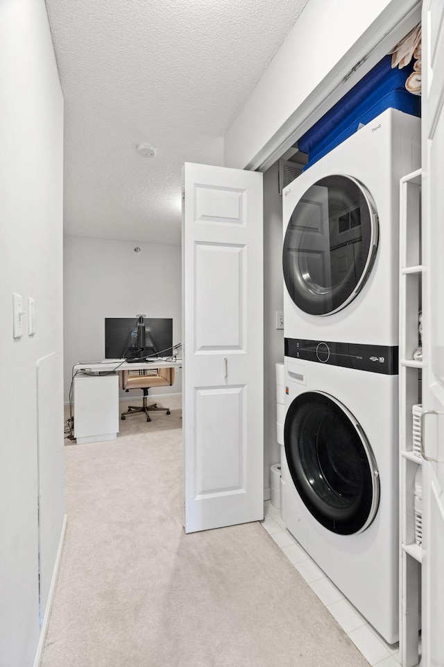 660 2nd St Unit 104, Minneapolis, MN 55401 - laundry area featuring estacked washer and dryer, carpet floors, an office area, and a textured ceiling