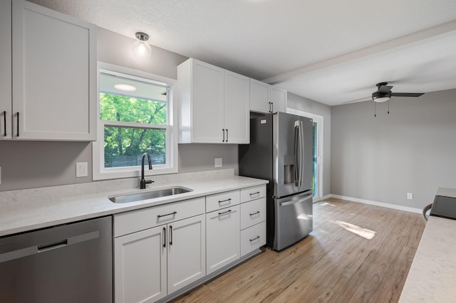 11632 Utah Ave N, Champlin, MN 55316 - kitchen featuring stainless steel appliances, light countertops, a ceiling fan, light wood-style floors, and white cabinetry