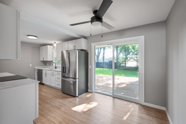 11632 Utah Ave N, Champlin, MN 55316 - kitchen with appliances with stainless steel finishes, light countertops, a ceiling fan, white cabinets, and light wood finished floors