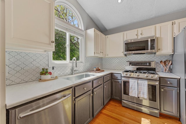 14349 Natchez Ave, Savage, MN 55378 - kitchen with stainless steel appliances, vaulted ceiling, light countertops, a textured ceiling, and tasteful backsplash