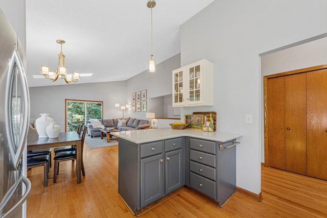14349 Natchez Ave, Savage, MN 55378 - kitchen featuring gray cabinets, freestanding refrigerator, light wood finished floors, a chandelier, and lofted ceiling
