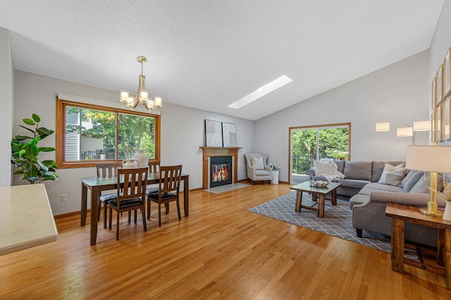 14349 Natchez Ave, Savage, MN 55378 - living room featuring light wood finished floors, plenty of natural light, a fireplace with flush hearth, a chandelier, and lofted ceiling