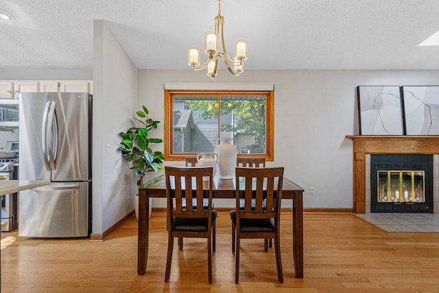 14349 Natchez Ave, Savage, MN 55378 - dining room featuring a chandelier, light wood-style flooring, a fireplace, and a textured ceiling