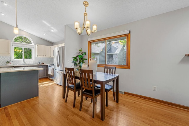 14349 Natchez Ave, Savage, MN 55378 - dining room with light wood-style floors, a chandelier, vaulted ceiling, a textured ceiling, and recessed lighting