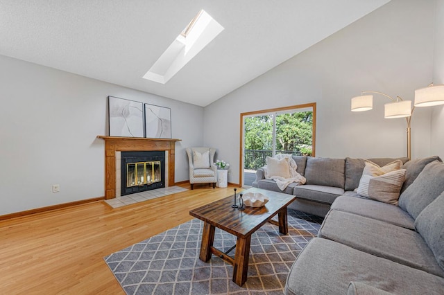 14349 Natchez Ave, Savage, MN 55378 - living room featuring wood finished floors, a skylight, a fireplace with flush hearth, and lofted ceiling