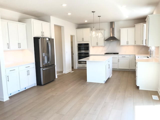 20071 67th Pl, Corcoran, MN 55340 - kitchen featuring stainless steel appliances, a center island, wall chimney exhaust hood, recessed lighting, and light wood-type flooring