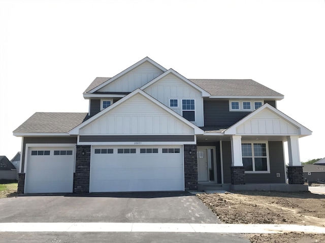 20071 67th Pl, Corcoran, MN 55340 - craftsman house featuring board and batten siding, a shingled roof, covered porch, driveway, and a garage
