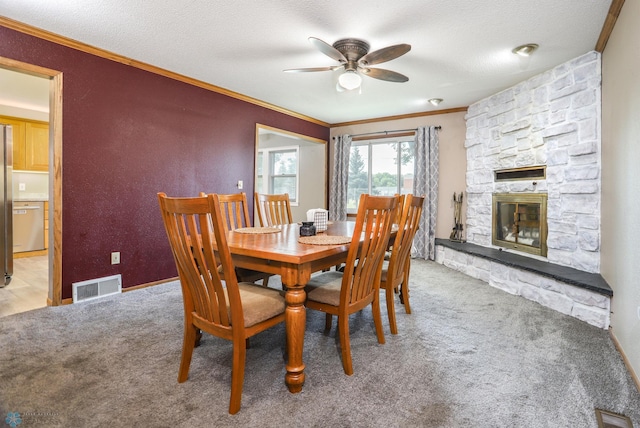 921 16th St S, Fargo, ND 58103 - carpeted dining space featuring crown molding, a ceiling fan, a fireplace, and a textured ceiling
