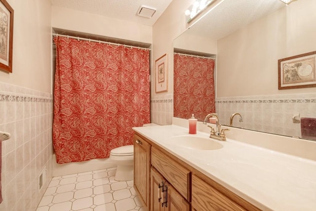 251 Revere Ln N, Champlin, MN 55316 - full bath featuring tile walls, vanity, a wainscoted wall, a textured ceiling, and tile patterned floors