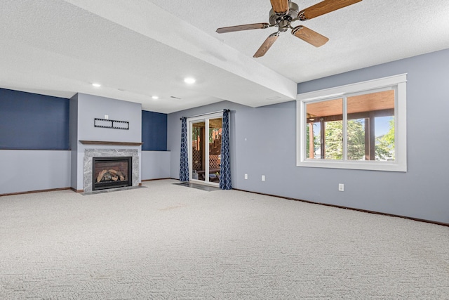 16951 88th Ave N, Maple Grove, MN 55311 - unfurnished living room featuring healthy amount of natural light, carpet floors, a premium fireplace, a textured ceiling, and ceiling fan