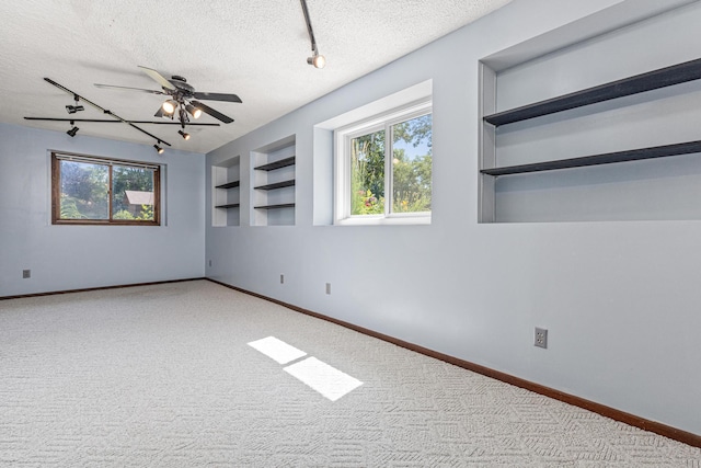 16951 88th Ave N, Maple Grove, MN 55311 - unfurnished room with track lighting, a textured ceiling, built in shelves, and plenty of natural light
