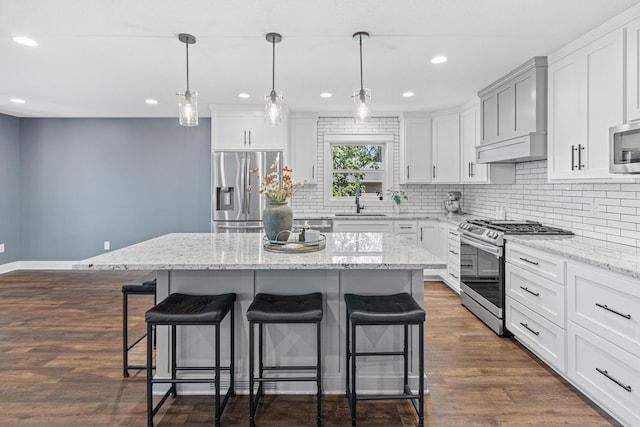 16951 88th Ave N, Maple Grove, MN 55311 - kitchen featuring appliances with stainless steel finishes, a kitchen breakfast bar, decorative backsplash, a kitchen island, and dark wood-style floors