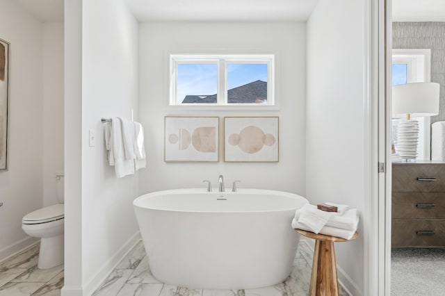 1938 Tamarack Rd, Carver, MN 55315 - bathroom featuring marble look tiles, a freestanding tub, and plenty of natural light