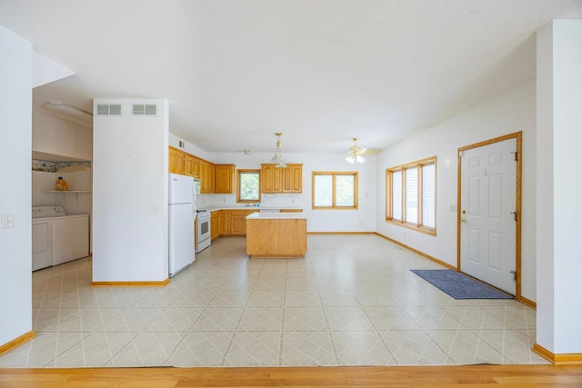 23865 County Rd, Loretto, MN 55357 - kitchen featuring washing machine and dryer, light countertops, a kitchen island, white appliances, and ceiling fan