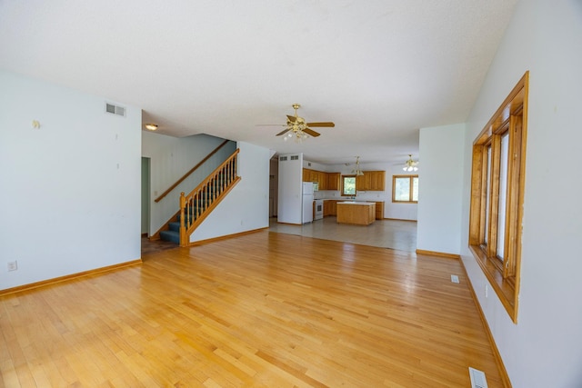 23865 County Rd, Loretto, MN 55357 - unfurnished living room featuring ceiling fan, light wood-style floors, and stairway