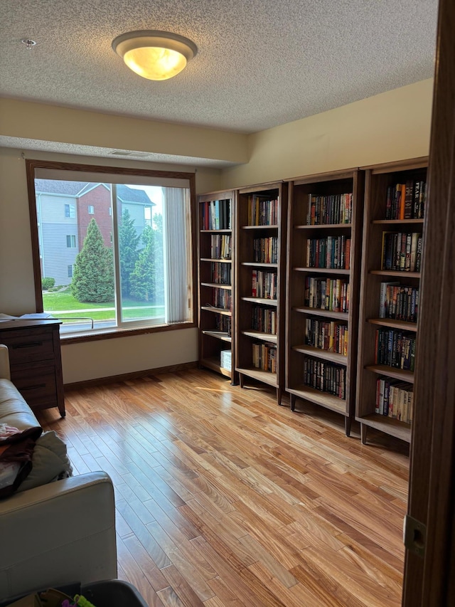 13670 Carrach Ave Unit 214, Rosemount, MN 55068 - sitting room with a textured ceiling, light wood finished floors, and bookshelves