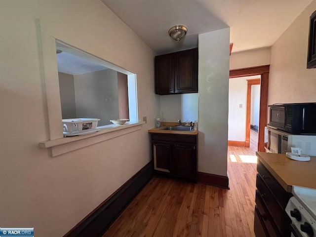 1027 Chapman St, Ely, MN 55731 - kitchen with black microwave, light countertops, dark wood-style floors, and dark brown cabinetry