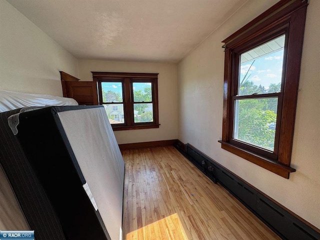 1027 Chapman St, Ely, MN 55731 - unfurnished bedroom with a baseboard radiator and light wood-style floors
