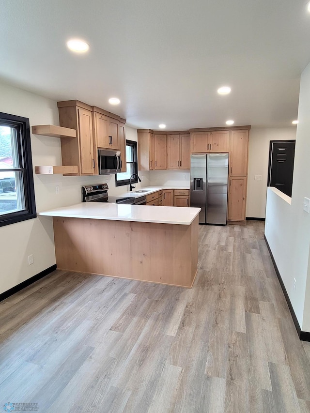 327 Mickey Mouse Ave, Horace, ND 58047 - kitchen with a peninsula, appliances with stainless steel finishes, light countertops, open shelves, and light wood finished floors