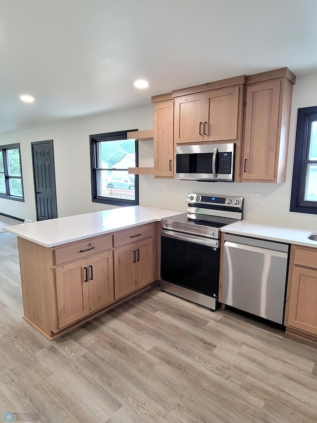 327 Mickey Mouse Ave, Horace, ND 58047 - kitchen featuring stainless steel appliances, a peninsula, light wood finished floors, healthy amount of natural light, and recessed lighting