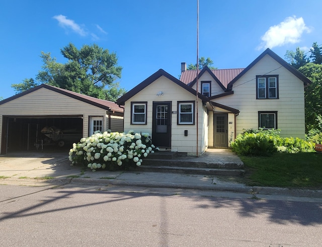 211 2nd St, Hatfield, MN 56164 - view of front of home with a garage, concrete driveway, a metal roof, and an outbuilding