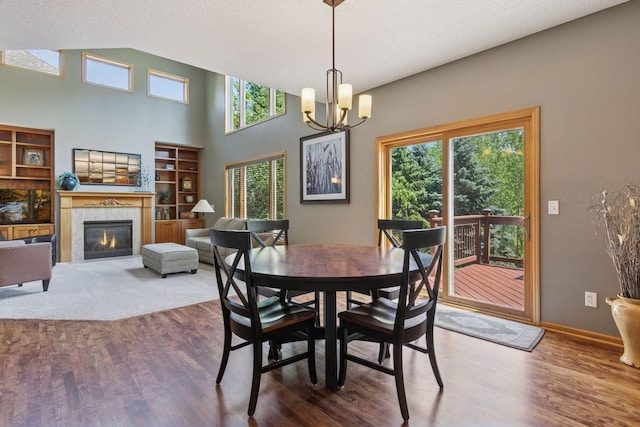 13836 Clare Downs Way, Rosemount, MN 55068 - dining area featuring wood finished floors, a chandelier, a fireplace, and a textured ceiling