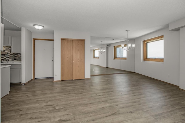 66 9th St E Unit 2315, Saint Paul, MN 55101 - unfurnished living room featuring a chandelier, wood finished floors, and a textured ceiling