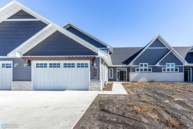 5820 31st St S, Fargo, ND 58104 - view of front of home featuring stone siding, concrete driveway, and a garage