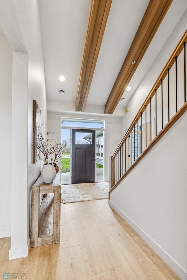 entrance foyer with light hardwood / wood-style floors and beam ceiling