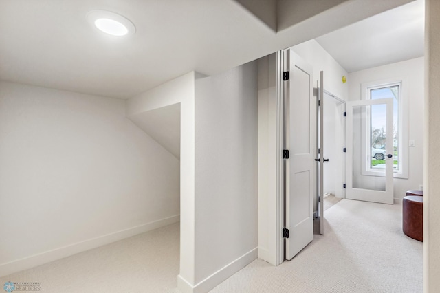 hallway with light colored carpet and french doors