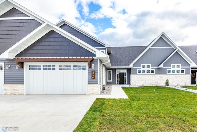 craftsman-style house featuring a front lawn and a garage