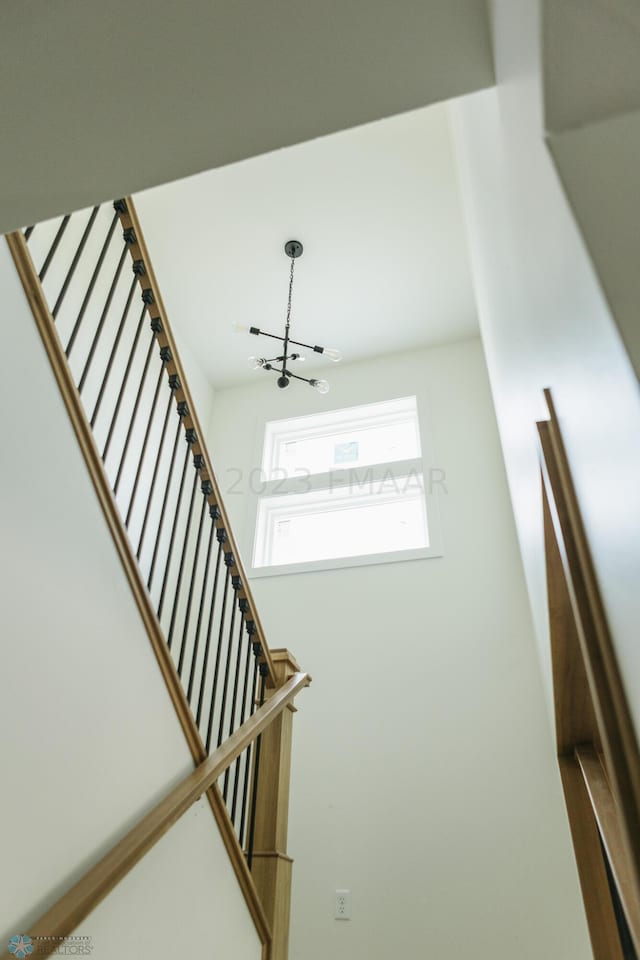 stairway featuring a chandelier