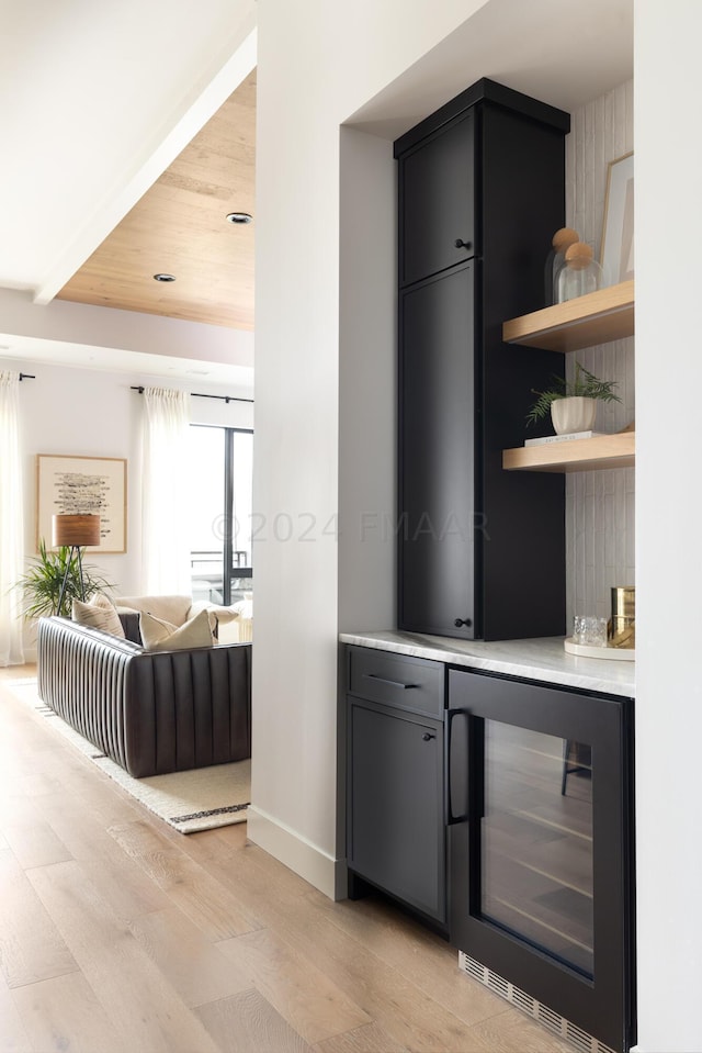 bar featuring light wood-type flooring, beverage cooler, and wood ceiling