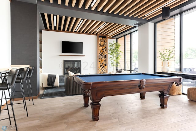 rec room with beamed ceiling, a wall of windows, pool table, and light hardwood / wood-style flooring