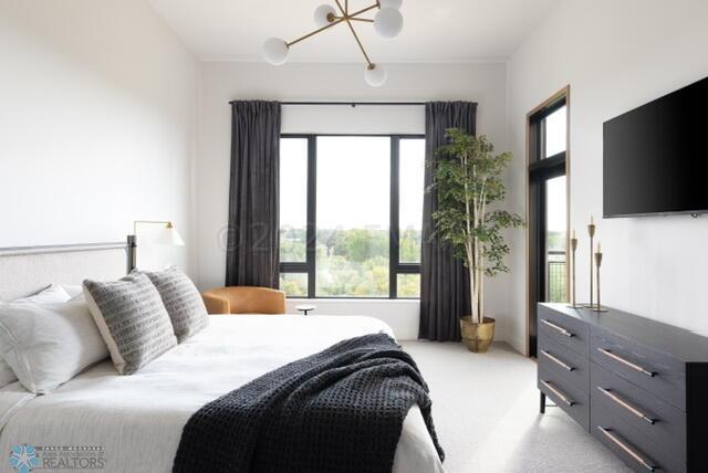 carpeted bedroom featuring a notable chandelier