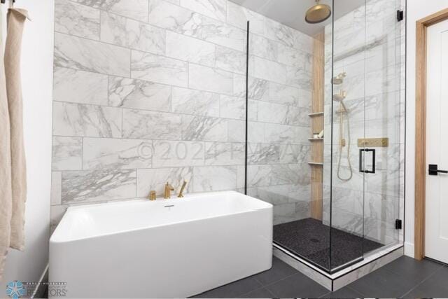 bathroom with tile patterned flooring, shower with separate bathtub, and tile walls