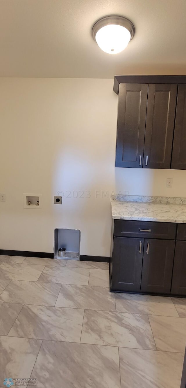 kitchen featuring light stone countertops and dark brown cabinets