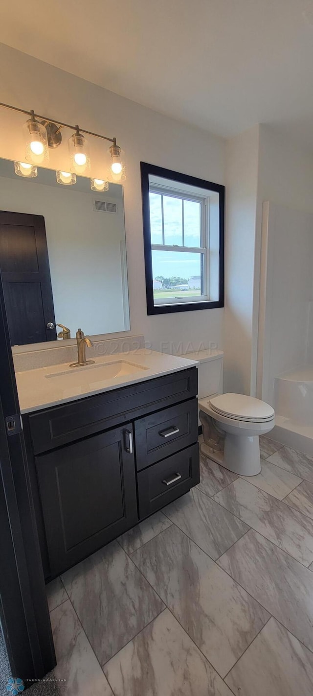 bathroom featuring vanity and toilet