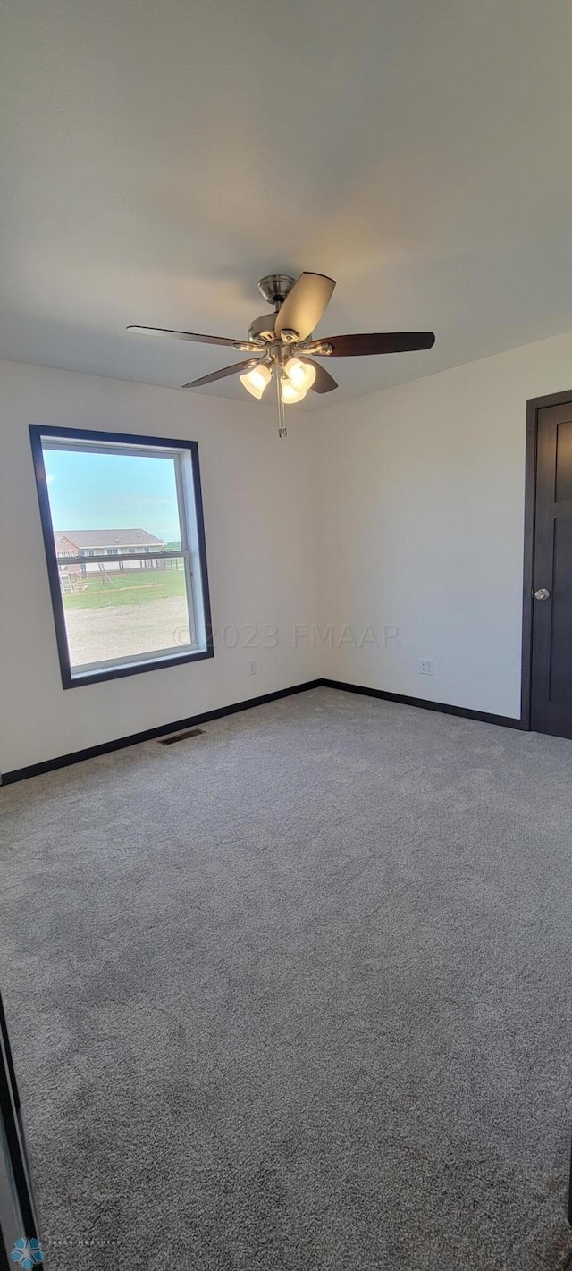 unfurnished room featuring ceiling fan and carpet