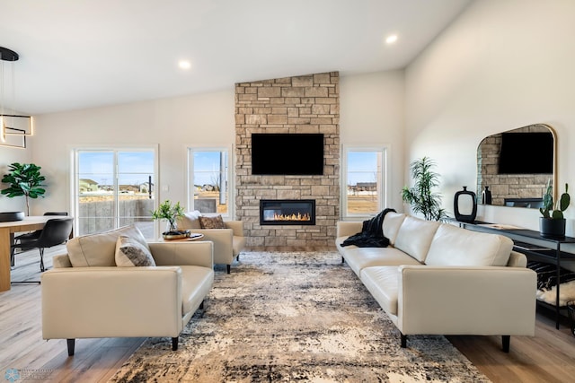 living room featuring a fireplace, vaulted ceiling, and hardwood / wood-style flooring