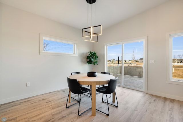 dining space with lofted ceiling and light hardwood / wood-style flooring