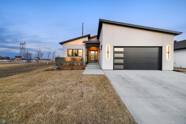 contemporary home featuring a garage and a front lawn