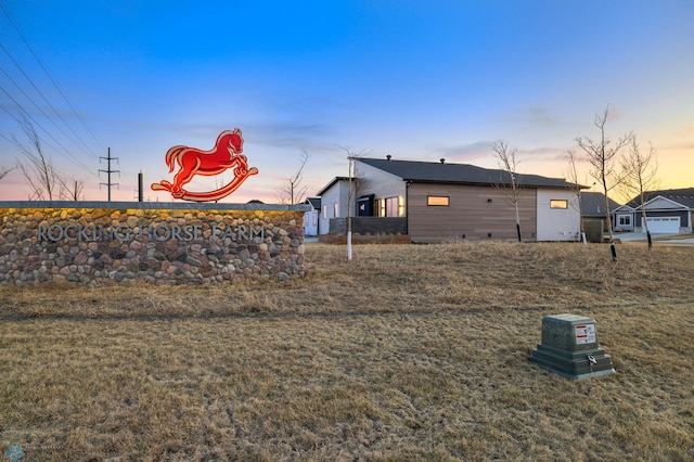 property exterior at dusk featuring a yard