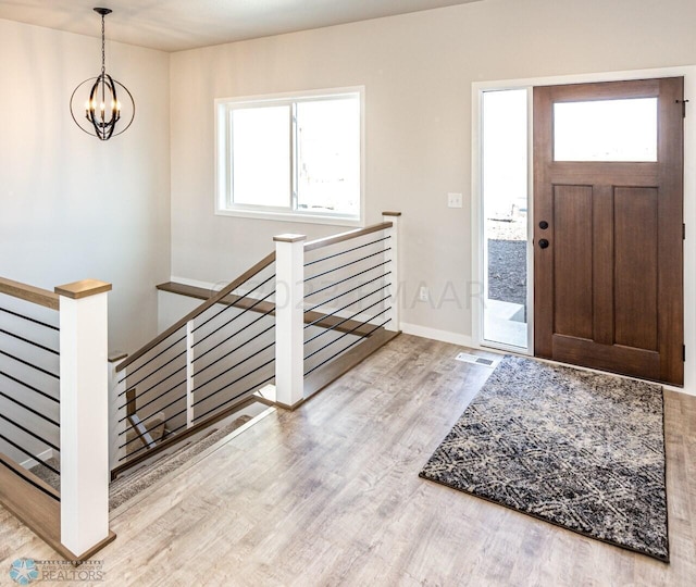 entrance foyer with light wood-type flooring and an inviting chandelier