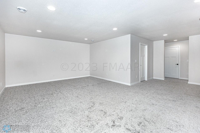 spare room with carpet and a textured ceiling