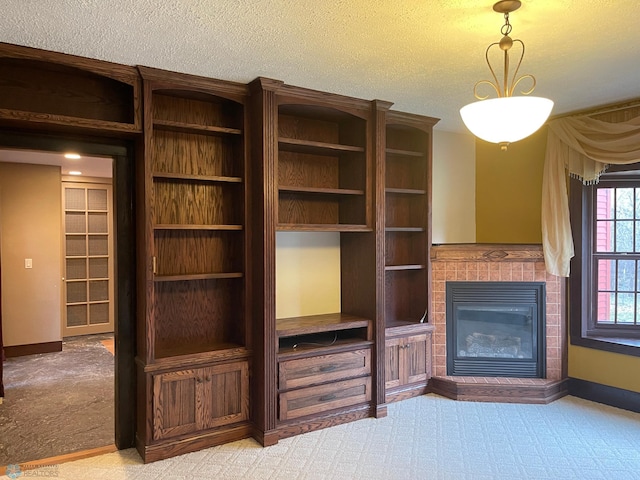 unfurnished living room with light colored carpet, a tiled fireplace, and a textured ceiling