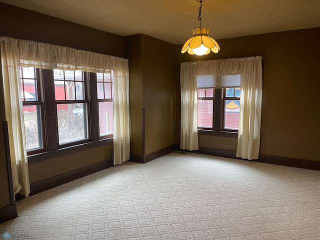 carpeted spare room featuring a textured ceiling