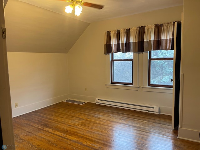 additional living space with a baseboard heating unit, ceiling fan, vaulted ceiling, and dark wood-type flooring