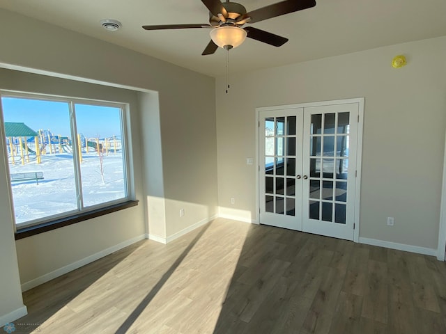 spare room with french doors, ceiling fan, and dark wood-type flooring